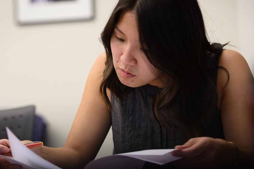 A young woman reading a paper