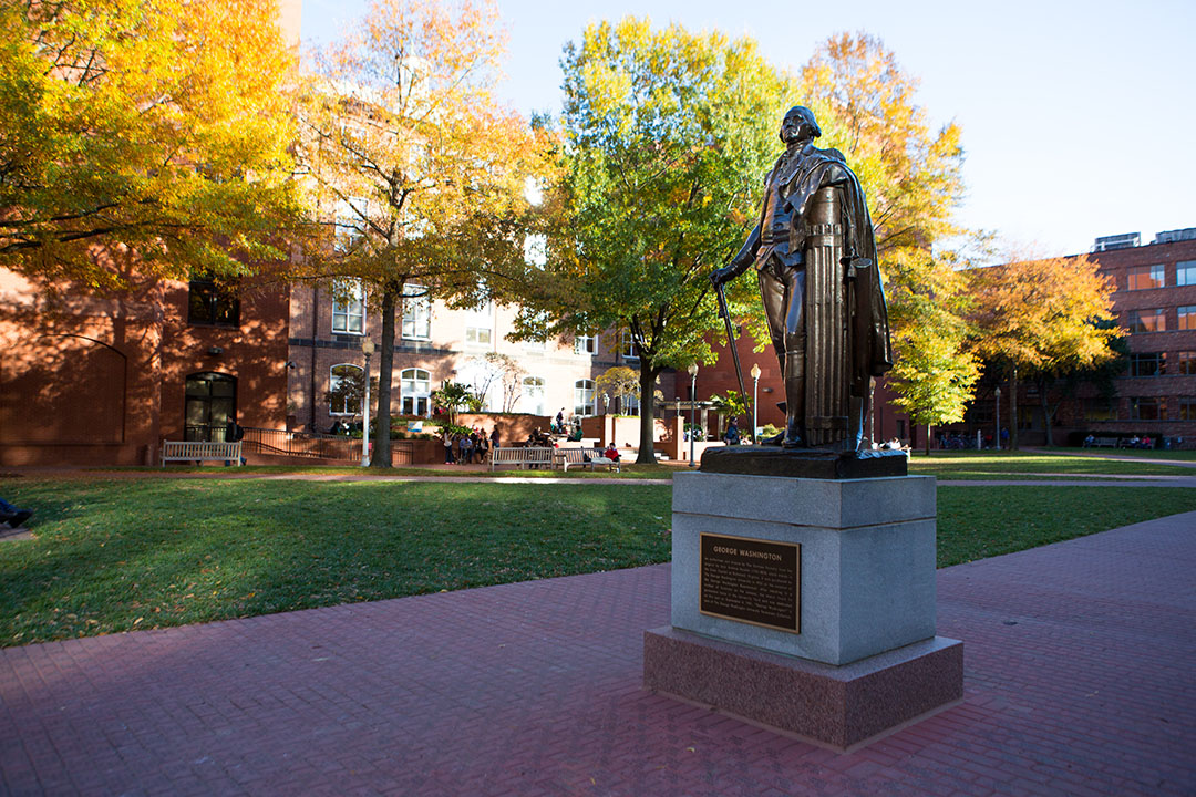 Statue of George Washington in the middle of University Yard, with autumn leaves 