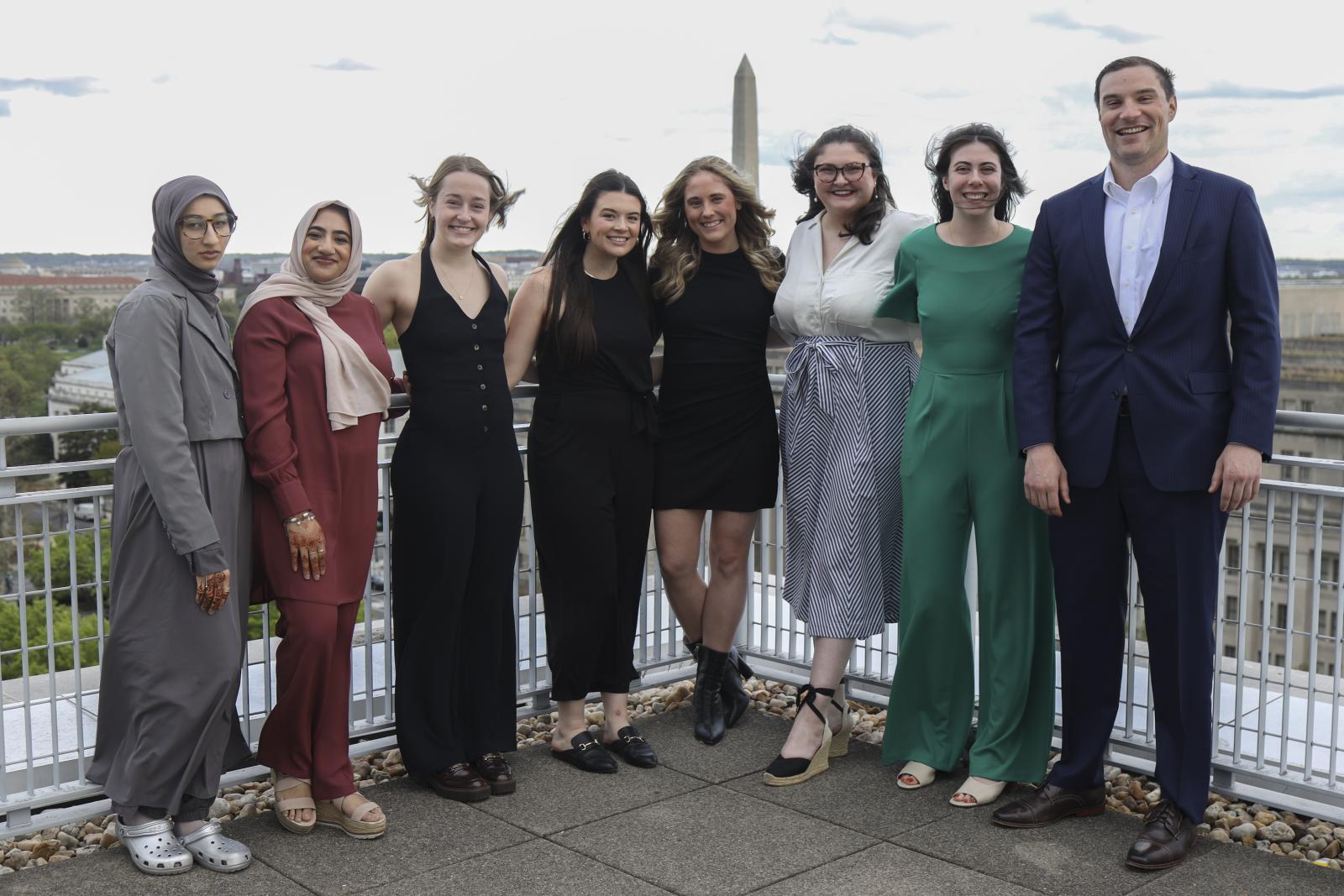 Students at the Pi Alpha Alpha ceremony on the outdoor patio. The washington monument is behind them.