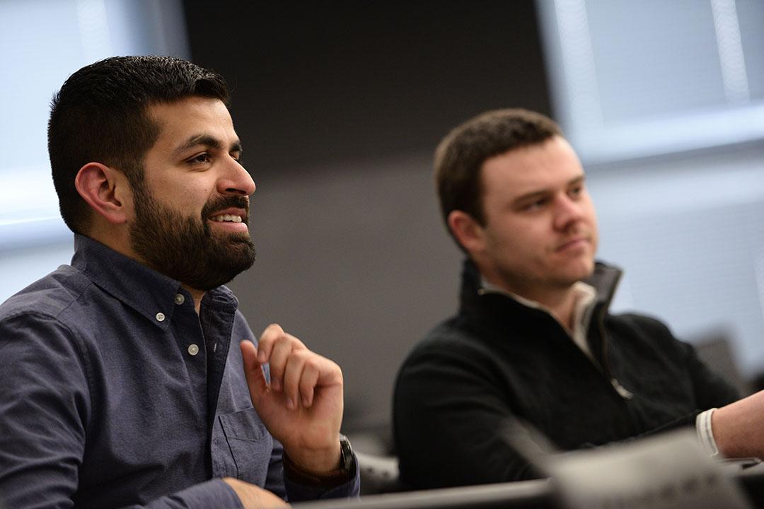 Close up of two students in profile smiling in a classroom